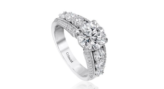 a white gold engagement ring with a wide band and a round cut center stone