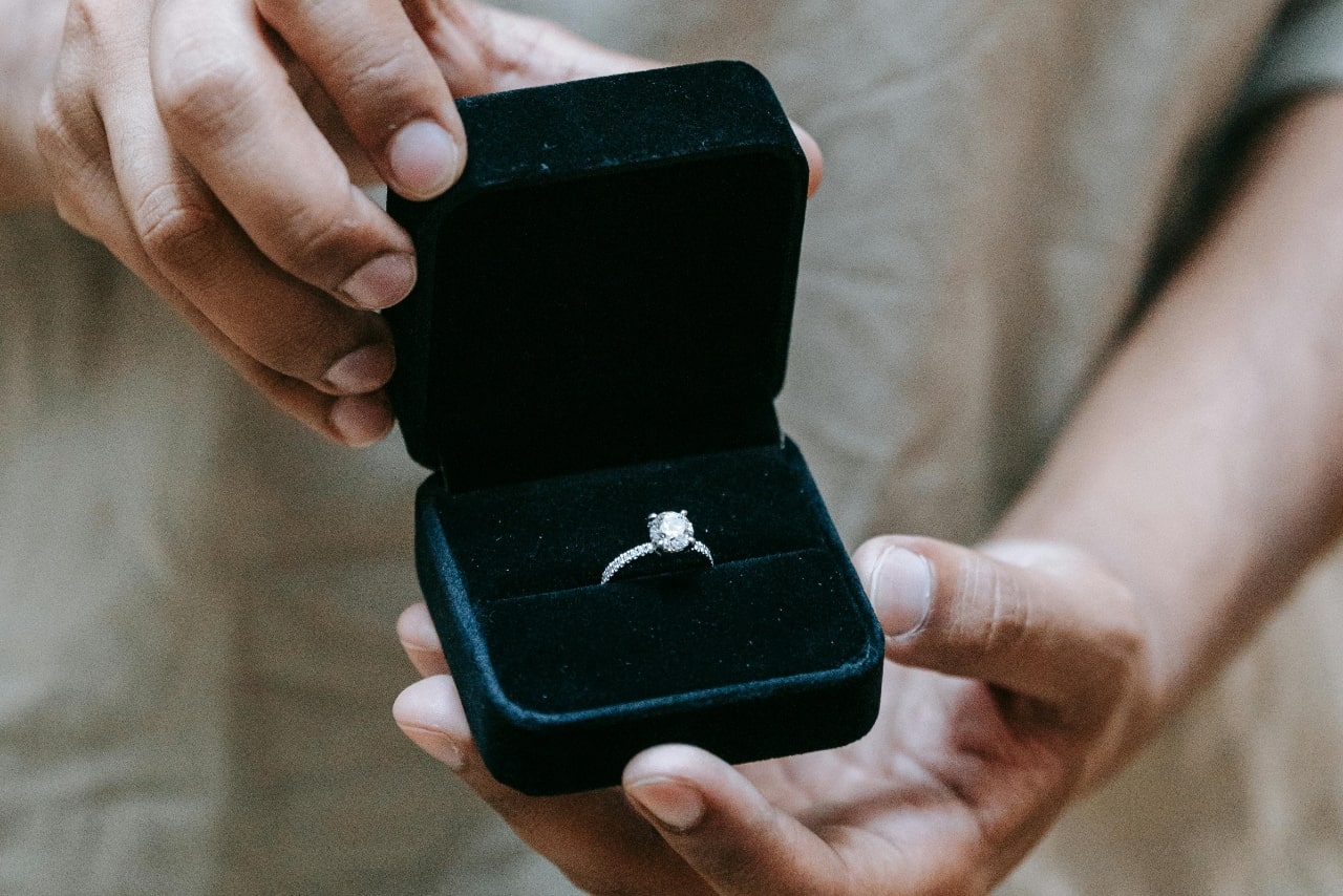 A white gold diamond engagement ring inside the turquoise velvet jewelry box