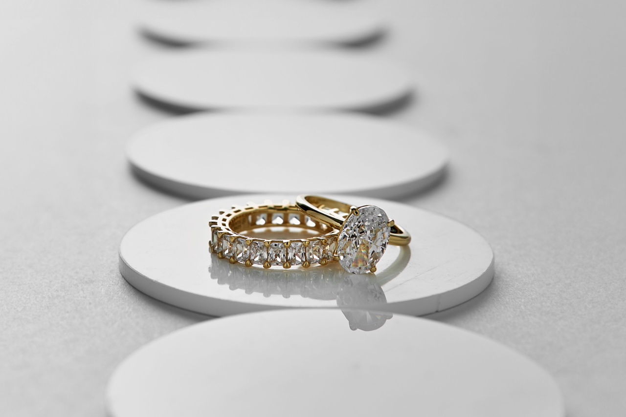 An oval cut engagement ring stacked over a radiant cut diamond eternity wedding band.