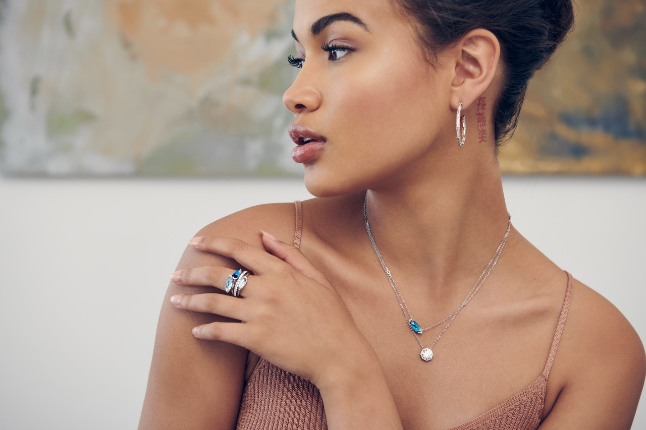 A woman wearing blue gemstone jewelry inside of a cafe.