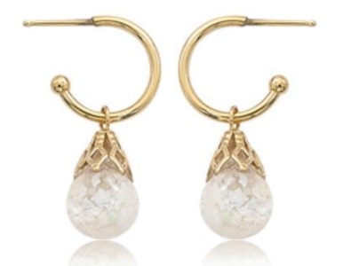 a pair of gold huggies earrings with opal drop accents.