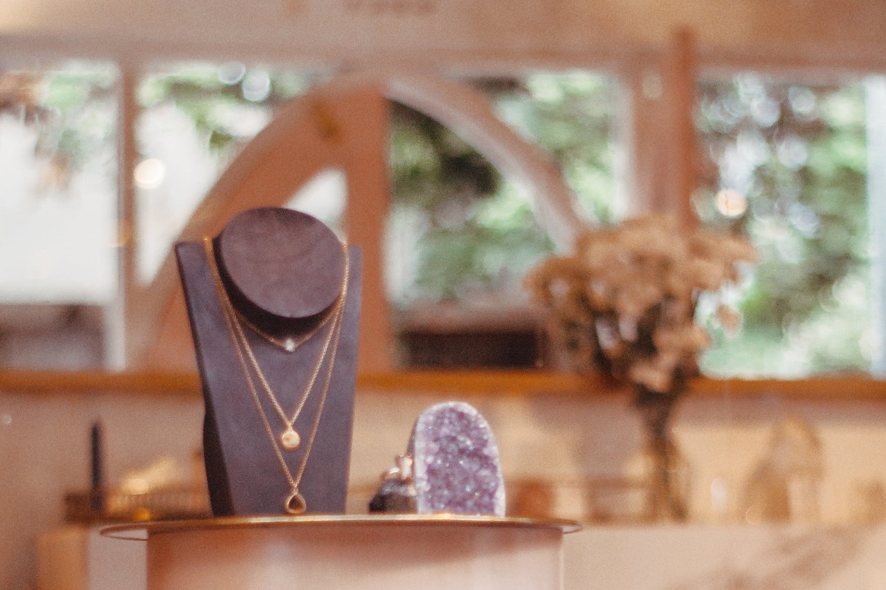 A view inside a jewelry store, including a display of 3 layered pendants.
