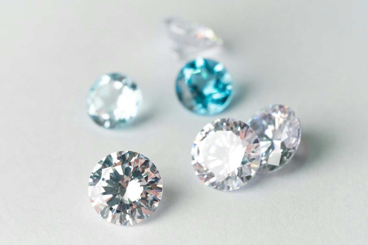 A collection of sparkling diamonds scattered on a light surface.