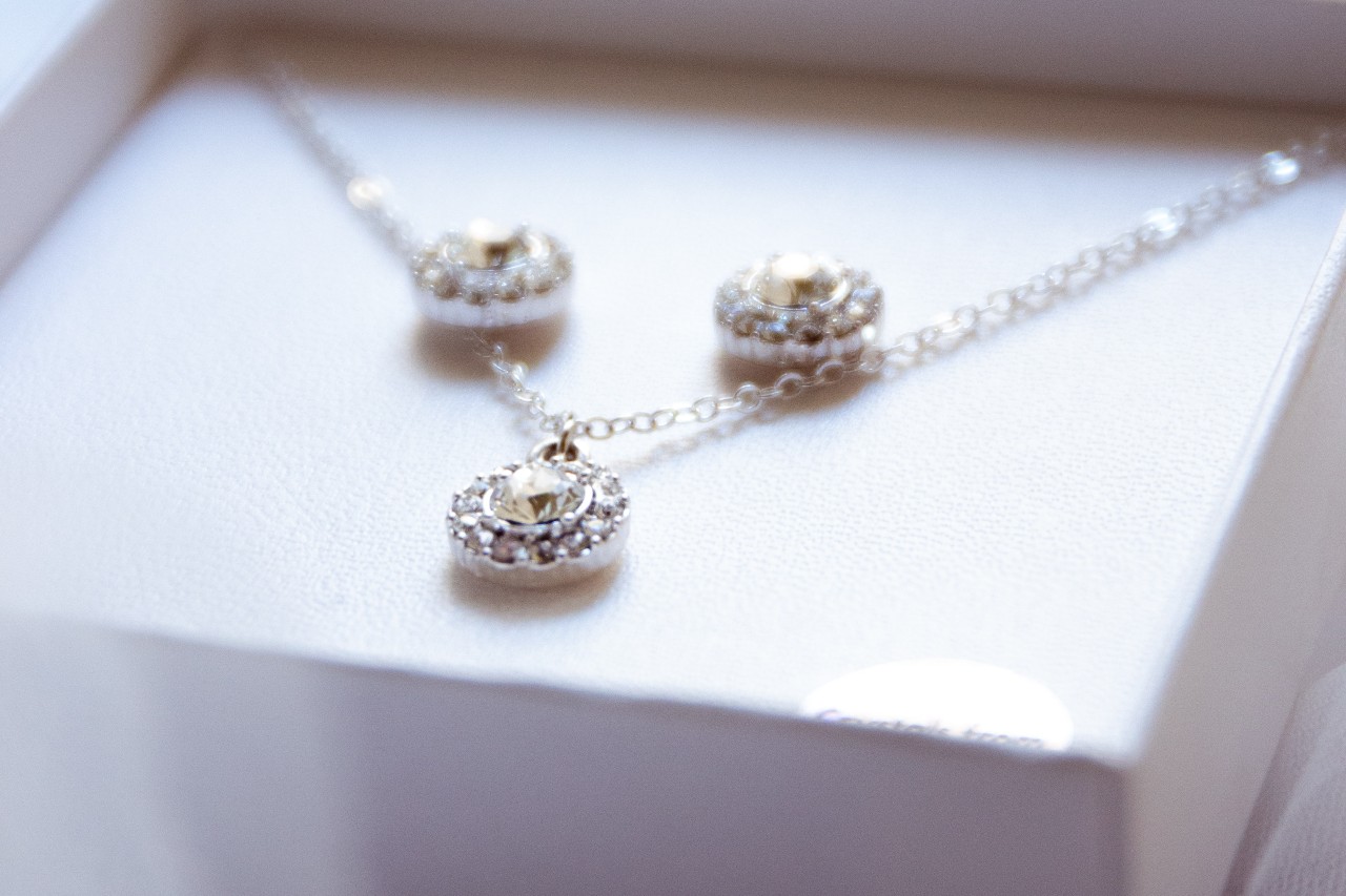 A delicate diamond necklace and earrings set in a white box