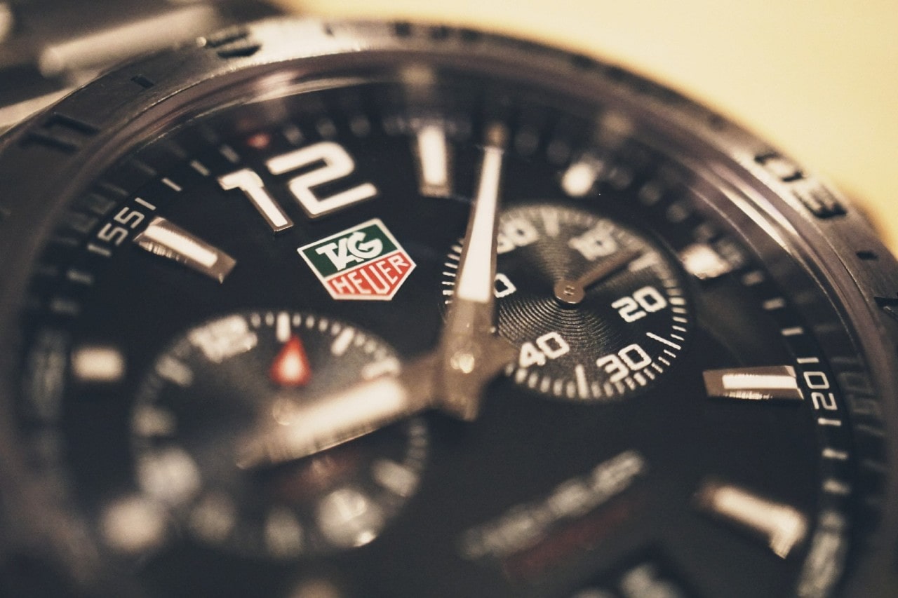 A close-up of a Tag Heuer black dial with two complications