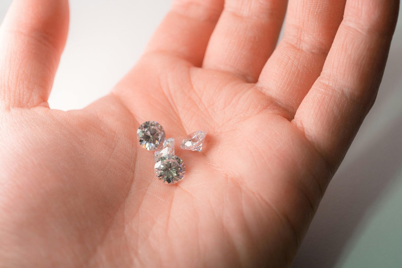 A close-up of a person’s palm with multiple diamonds on it.