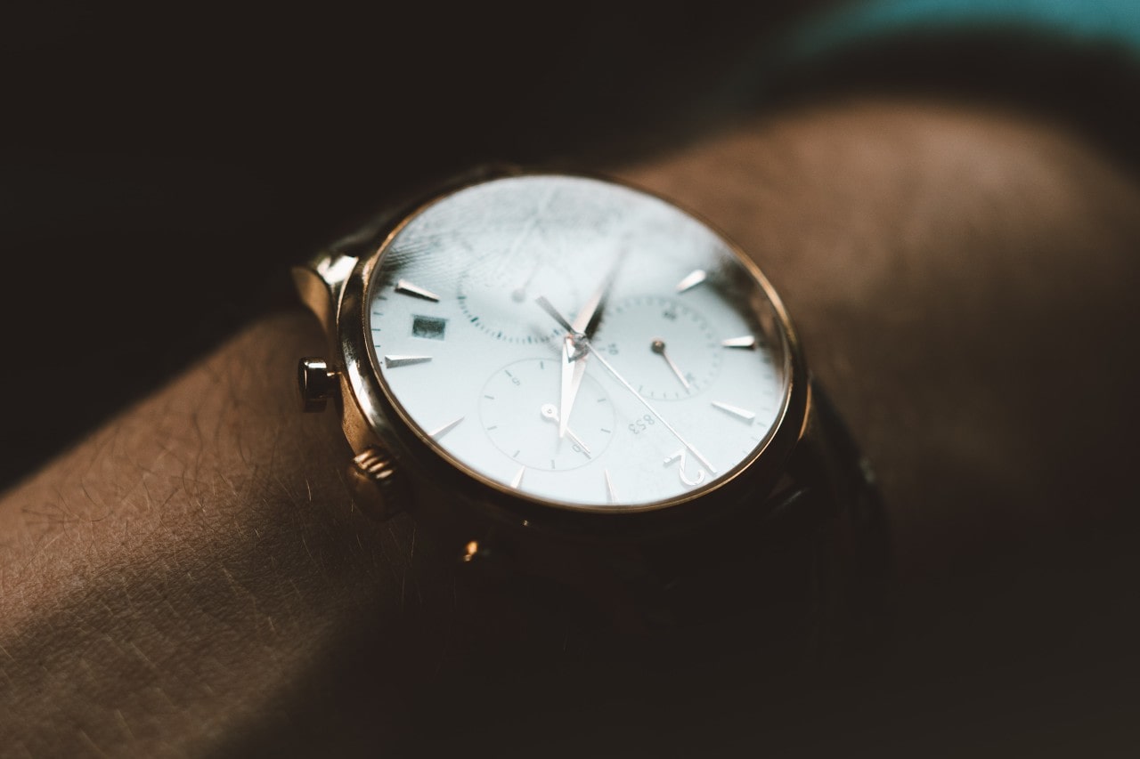 A closeup of a minimalist watch face on a man’s wrist.