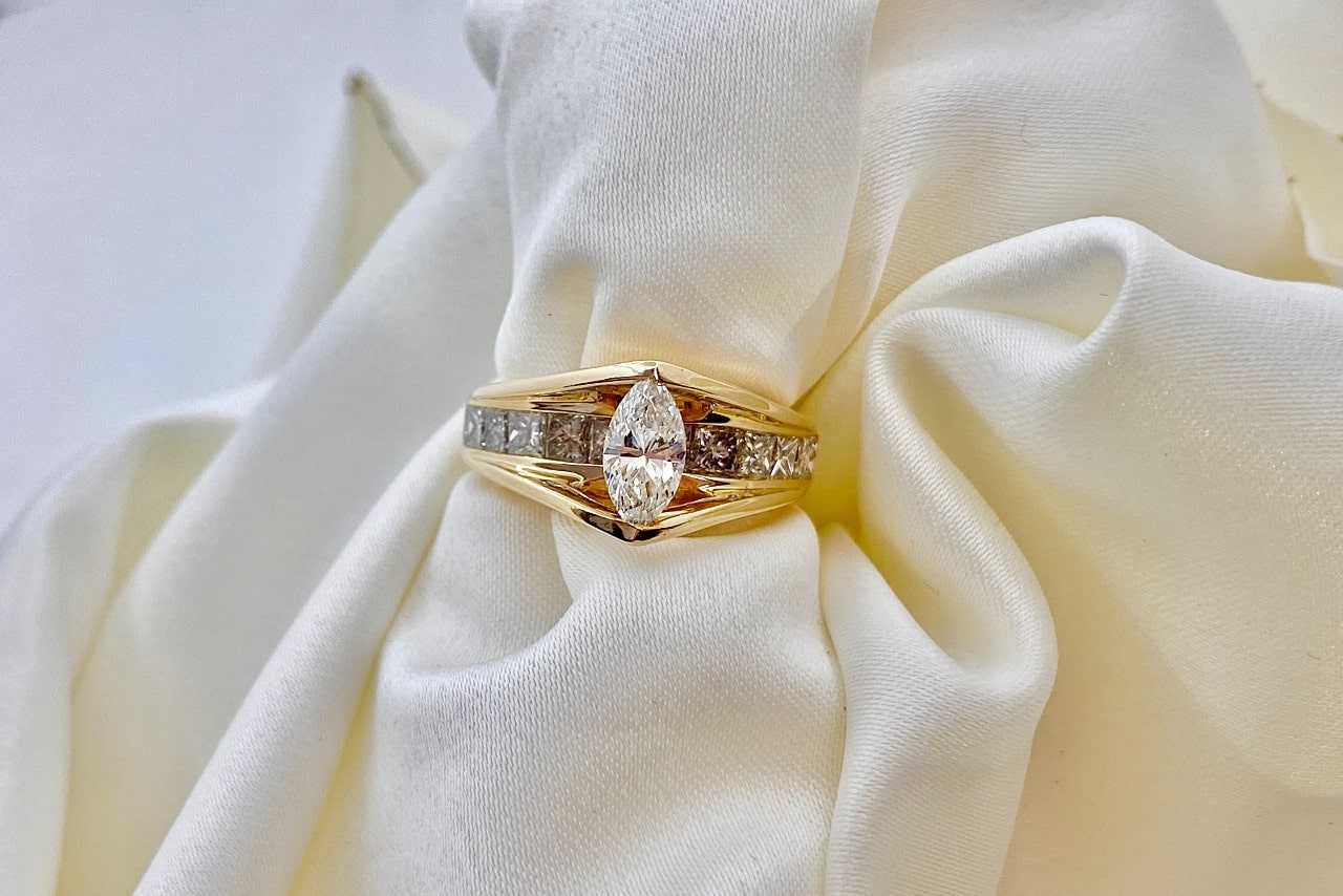 a thick banded engagement ring sitting on a piece of white fabric