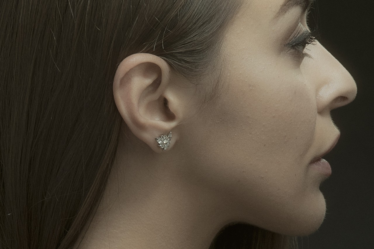a woman facing away from the camera and wearing a diamond stud earring
